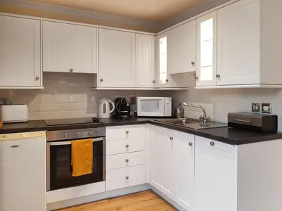 a white kitchen with white cabinets and a microwave at Leven Lodge 1 - Uk46042 in Balloch