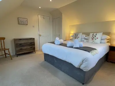 a bedroom with a large bed with stuffed animals on it at The Cottage, overlooking Loch Fyne in Cairndow