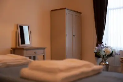 a bedroom with a bed and a cabinet and a vase of flowers at Saskatchewan House in Oban