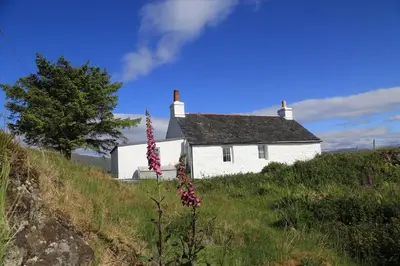 a white house sitting on top of a hill at Archie's Cottage in Auchnacraig