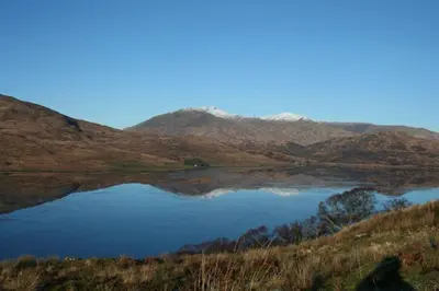 a lake with a mountain in the background at Barrachandroman Farmhouse in Lochbuie