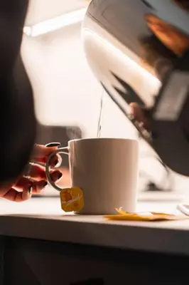 a person is pouring coffee into a cup on a counter at The West End Retreat - Your Luxurious 5* Apartment in Glasgow