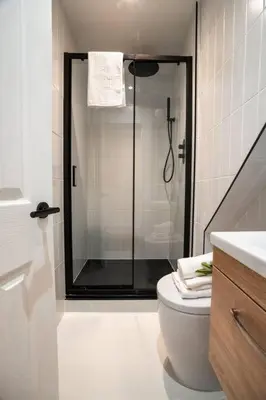 a bathroom with a shower with a toilet and a sink at The West End Retreat - Your Luxurious 5* Apartment in Glasgow
