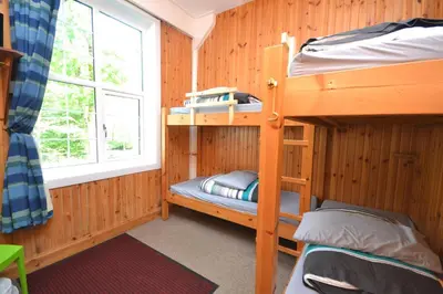 a bunk bed room with two bunk beds and a window at Blackwater Hostel in Kinlochleven