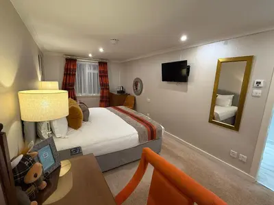 a hotel room with a bed and a mirror at The Airds Hotel and Restaurant in Port Appin