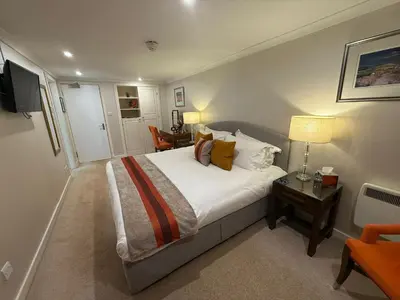 a bedroom with a bed and a table with a lamp at The Airds Hotel and Restaurant in Port Appin