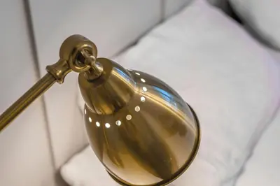 a gold light attached to a wall next to a bed at West Lothian 5 Beds + car space in Whitburn