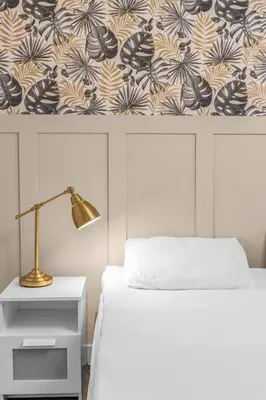a bedroom with a bed with a lamp and a wall at West Lothian 5 Beds + car space in Whitburn