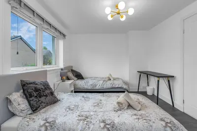 a bedroom with a large bed and a window at West Lothian 5 Beds + car space in Whitburn