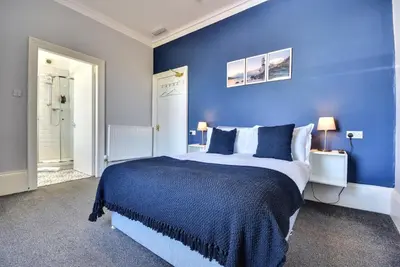 a blue bedroom with a large bed with blue walls at Exclusive Use in Gourock