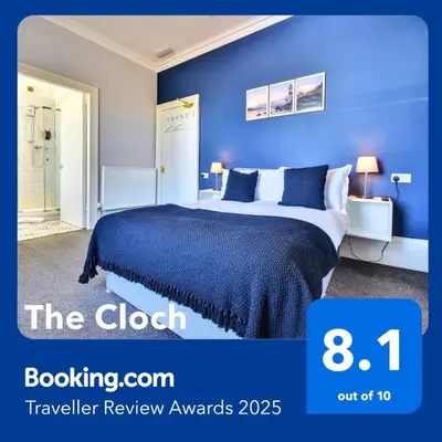 a bedroom with a bed with a blue wall at The Cloch in Gourock