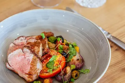 a bowl of food with meat and vegetables on a table at Braid Hills Hotel in Edinburgh