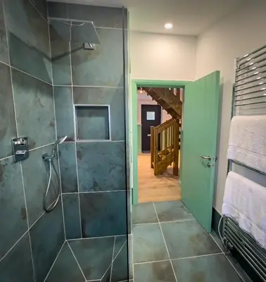 a bathroom with a shower with a glass door at Croft 11 Clovullin in Ardgour
