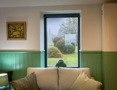 a couch sitting in a room with a window at Croft 11 Clovullin in Ardgour
