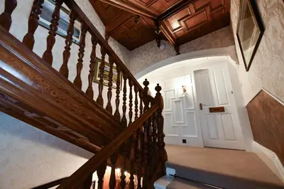 a wooden staircase with a white door in a house at The Townhouse Ayr - Luxury B&B - adults only in Ayr