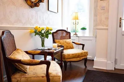 a living room with two chairs and a table with flowers at The Townhouse Ayr - Luxury B&B - adults only in Ayr