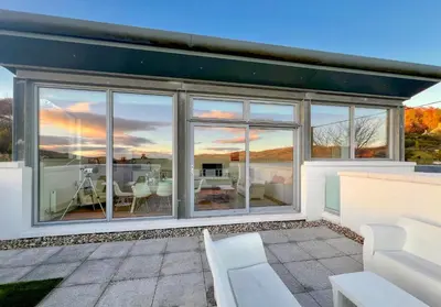 a house with large windows and a patio at Old Fire Station in Tighnabruaich