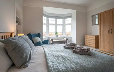 a bedroom with a large bed with towels on it at Argaty Cottage in Doune