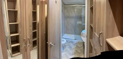a bathroom with a toilet and a glass door at Loubet Extra Large Lodge in Auchterarder