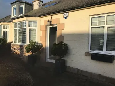 a house with two potted trees in front of a door at Ultra Stylish furnished Home in Edinburgh in Edinburgh
