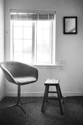 a chair and a stool in a room with a window at MHOR 84 in Kingshouse