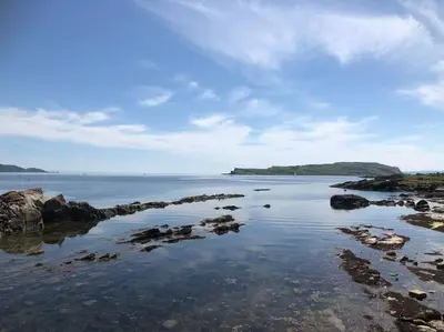 a view of the ocean with rocks in the water at Millport Beach Apartment, Crichton St, sea views in Millport
