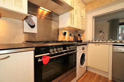 a kitchen with a stove and a washing machine at Signature - Shield House in Scotstoun