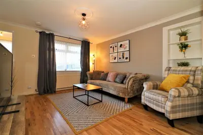 a living room with two couches and a table at Signature - Shield House in Scotstoun