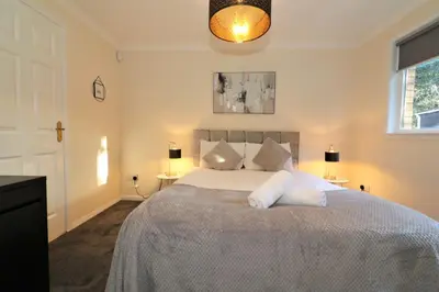 a bedroom with a bed with white sheets and a window at Signature - Shield House in Scotstoun