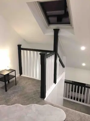 a room with a staircase with a black rail and a table at Tarbert large, bright, 4 bedroom flat with harbour views in Tarbert