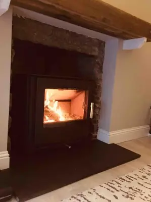 a fireplace in a living room with a fire in it at Tarbert large, bright, 4 bedroom flat with harbour views in Tarbert