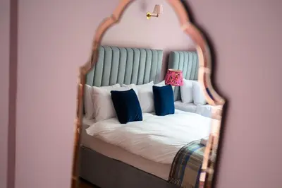 a bedroom with a bed in a mirror at Queen Charlotte Guesthouse in Edinburgh