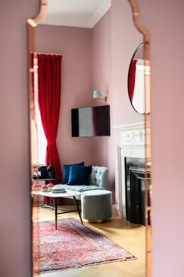 a living room with a couch and a mirror at Queen Charlotte Guesthouse in Edinburgh