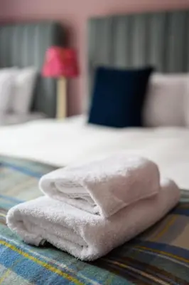 a pile of towels sitting on top of a bed at Queen Charlotte Guesthouse in Edinburgh