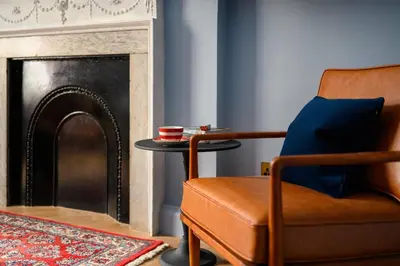 a living room with a chair and a table at Queen Charlotte Guesthouse in Edinburgh