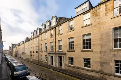 a large brick building with cars parked on a street at Destiny Scotland - Hill Street Apartments in Edinburgh