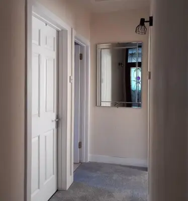 a hallway with a white door and a mirror at Springfield Apartment - Train to Glasgow or Edinburgh - Private Parking & Wifi in Airdrie