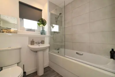 a bathroom with a sink and a toilet and a bath tub at Signature - Belvidere House in Glasgow