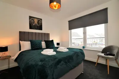 a bedroom with a bed with two towels on it at Signature - Belvidere House in Glasgow
