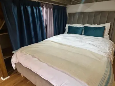 a bedroom with a large bed with blue curtains at Glasgow Center/West End Apartment in Glasgow
