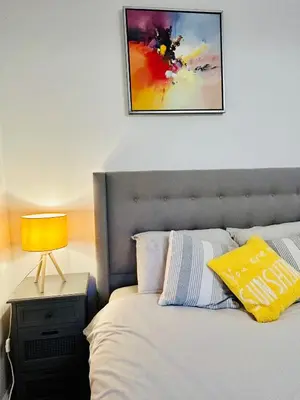 a bedroom with a bed with a lamp on a night stand at Glasgow Center/West End Apartment in Glasgow