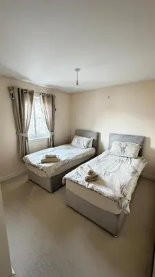 a bedroom with two beds and a window at 6 Tobar Oisinn in Oban