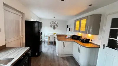 a kitchen with a black refrigerator and a counter at 6 Tobar Oisinn in Oban