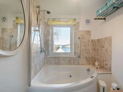 a white tub in a bathroom with a window at 1 Bed in Inveraray 91310 in Crarae