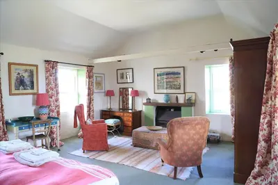 a bedroom with a bed and a table and chairs at Old Ferry House in Auchnacraig