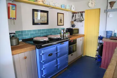 a small kitchen with a blue stove top oven at Old Ferry House in Auchnacraig