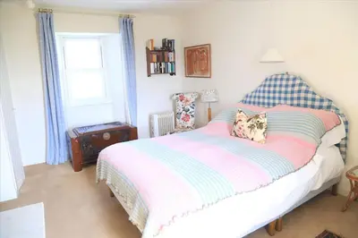 a bedroom with a bed with a pillow and a window at Old Ferry House in Auchnacraig