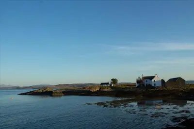 a house on a small island in the water at Old Ferry House in Auchnacraig