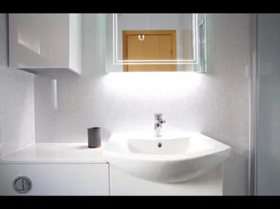 a bathroom with a white sink and a mirror at The Crannog on Loch Tay in Morenish