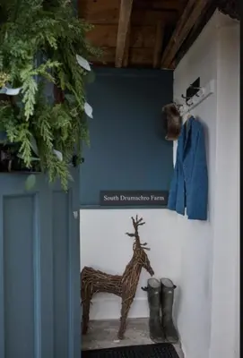 a statue of a giraffe and boots on a wall at ISLE OF GIGHA FARM HOUSE in Isle of Gigha